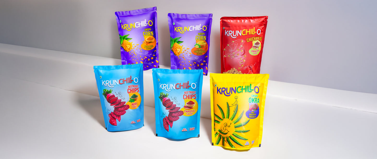Colorful packages of Krunchillo chips on a white surface with a gray background