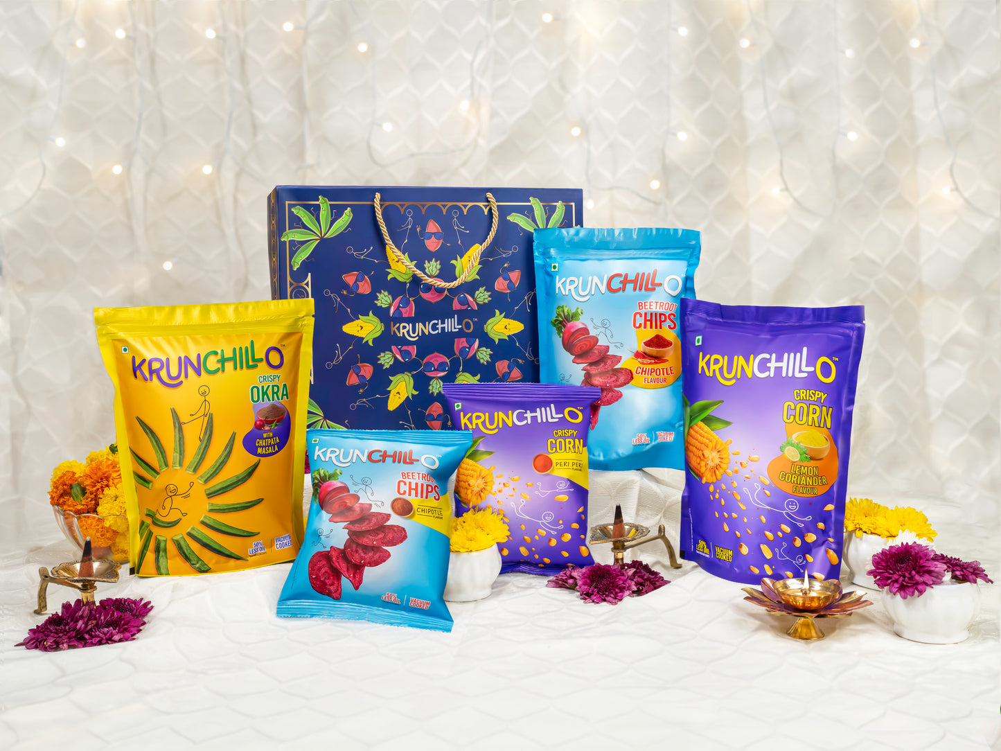 Assorted bags of Krunchillo snacks on a decorative background with lights.